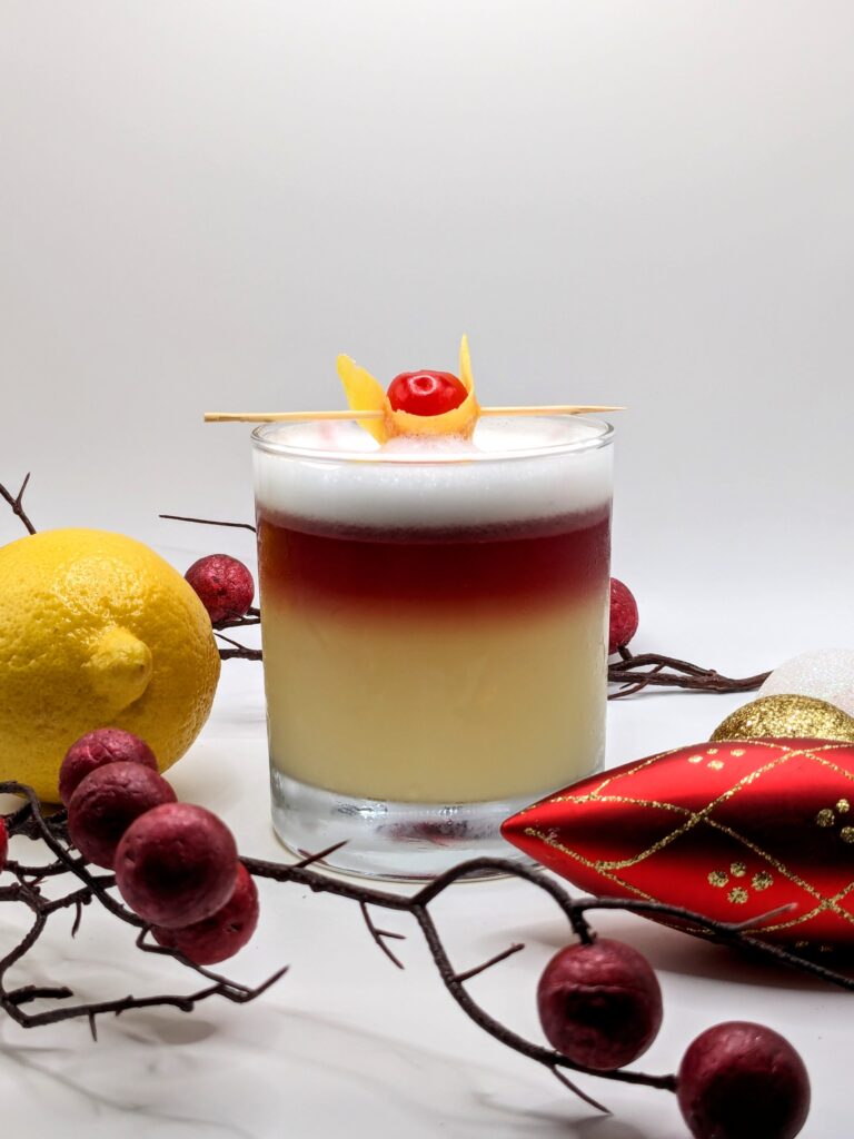 Winter sour cocktail made with Gin, red Wine and egg white